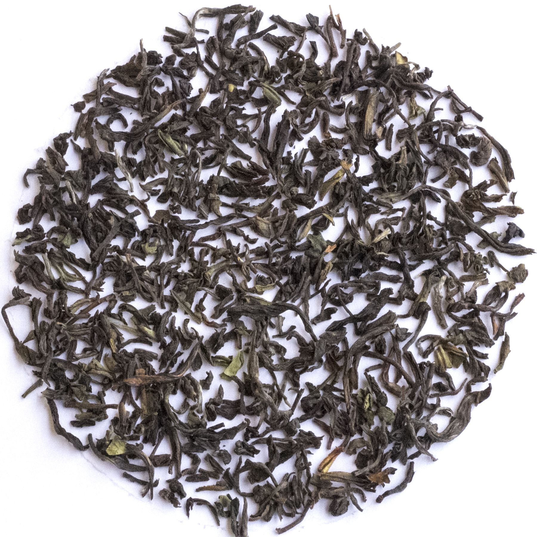 Loose-leaf tea leaves, dark brown and black with small green tips, arranged in a circular pile on a white background.