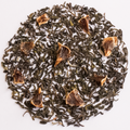 Loose leaf tea arranged in a circular pile on a white background, featuring dark green tea leaves with several dried citrus slice pieces mixed throughout.