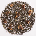 Loose-leaf tea blend with dark green rolled leaves and scattered dried citrus slices, arranged in a circular pile on a white background.