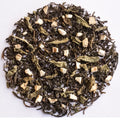 A circular arrangement of loose-leaf herbal tea blend on a plain white background, showing dark tea leaves mixed with pale dried flowers and small light beige chunks.