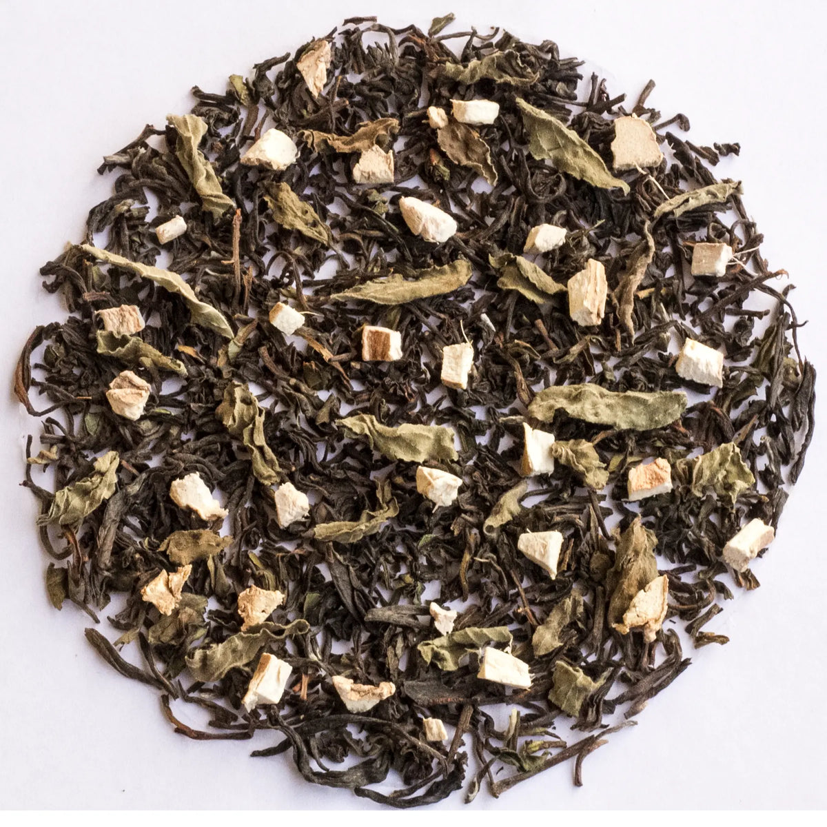 A circular arrangement of loose-leaf herbal tea blend on a plain white background, showing dark tea leaves mixed with pale dried flowers and small light beige chunks.