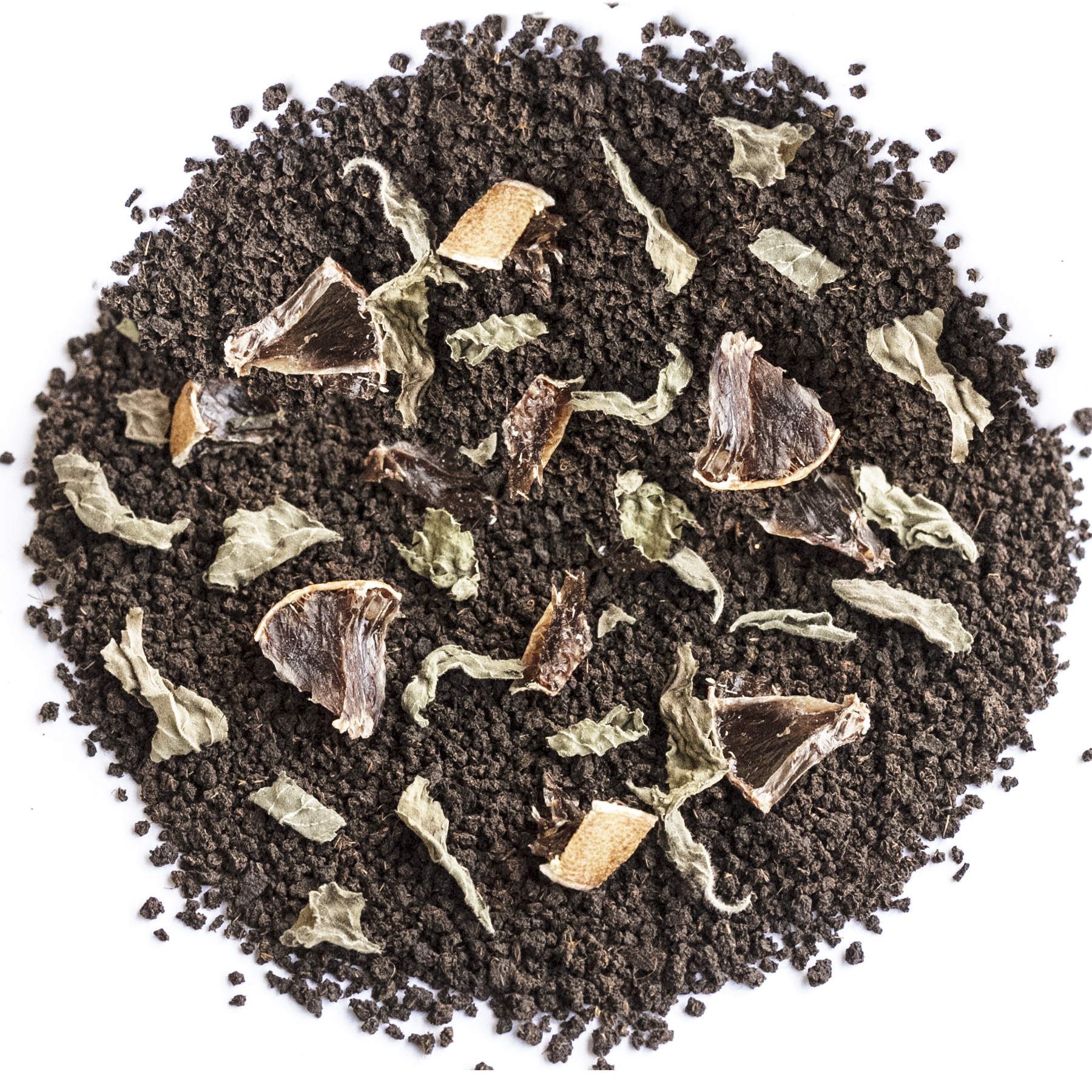 A top-down view of a circular pile of dark brown coffee grounds mixed with dried herbs, leaves, and small brown fruit pieces on a plain white background.