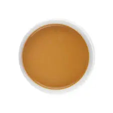 A circular swatch of warm tan-brown cosmetic cream or gel, presented on a clean white background.