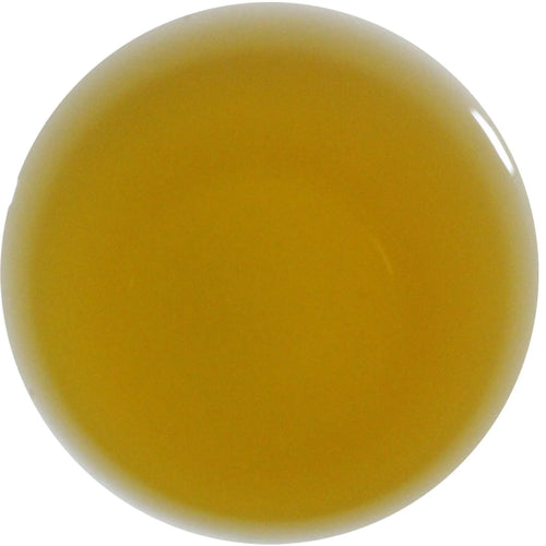 A smooth, glossy circular swatch of translucent ochre yellow gel or liquid on a solid white background.