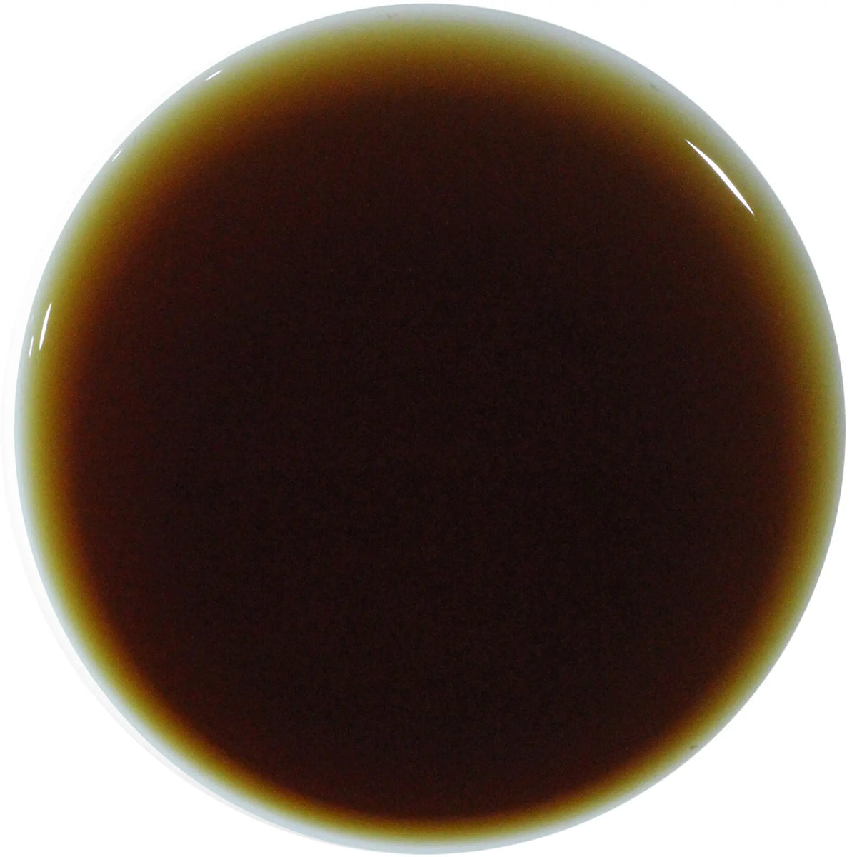 A circular close-up swatch of a dark brown glossy liquid or material sample on a white background.
