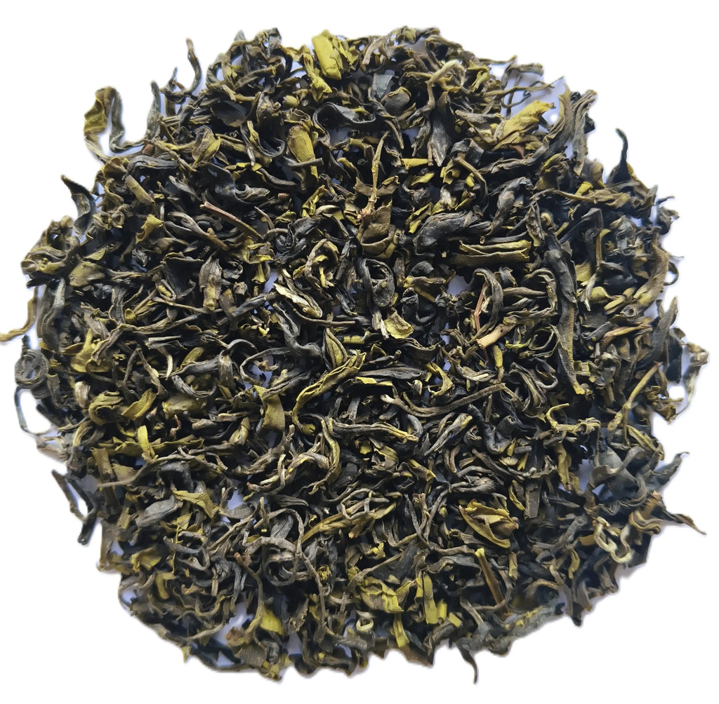 A pile of loose-leaf tea leaves, showing dark green to black rolled leaves with bright yellow-green tips, photographed on a plain white background.
