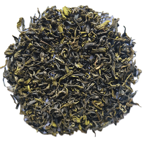 A pile of loose-leaf tea leaves, showing dark green to black rolled leaves with bright yellow-green tips, photographed on a plain white background.