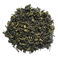 A pile of loose-leaf green tea leaves, showing their curly, rolled texture, photographed on a solid white background.