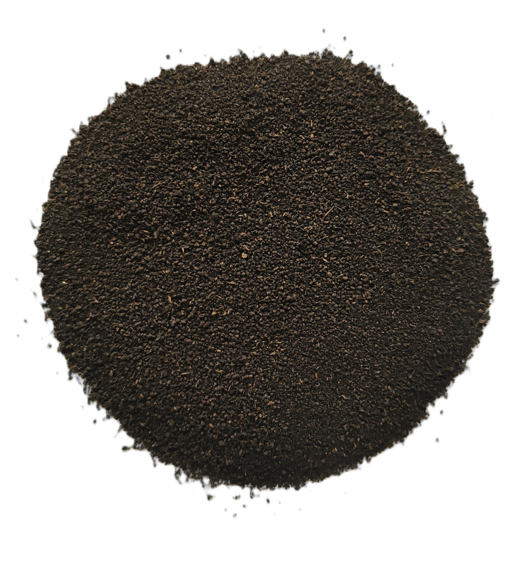 A mound of dark brown to near-black granular powder or fine solid material, photographed from above on a plain white background.