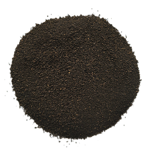 A mound of dark brown to near-black granular powder or fine solid material, photographed from above on a plain white background.