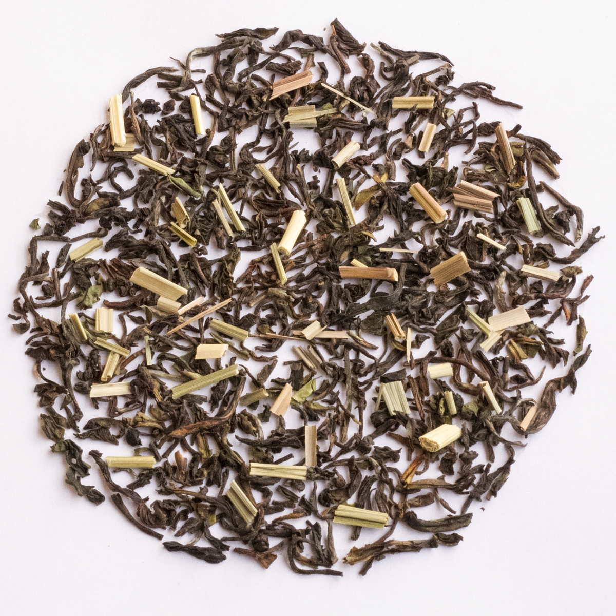 Lemongrass Black Tea blend with dark curled tea leaves and pale yellow-green cut lemongrass stalks on a white background