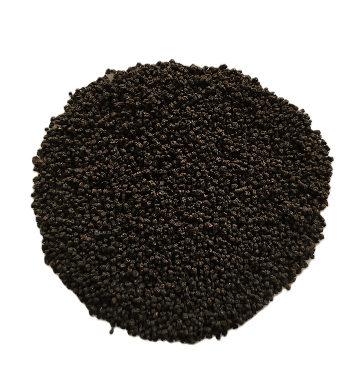 A pile of small dark brown to black granular particles, likely seed, soil, or coffee beans, arranged in a circular mound on a solid white background.