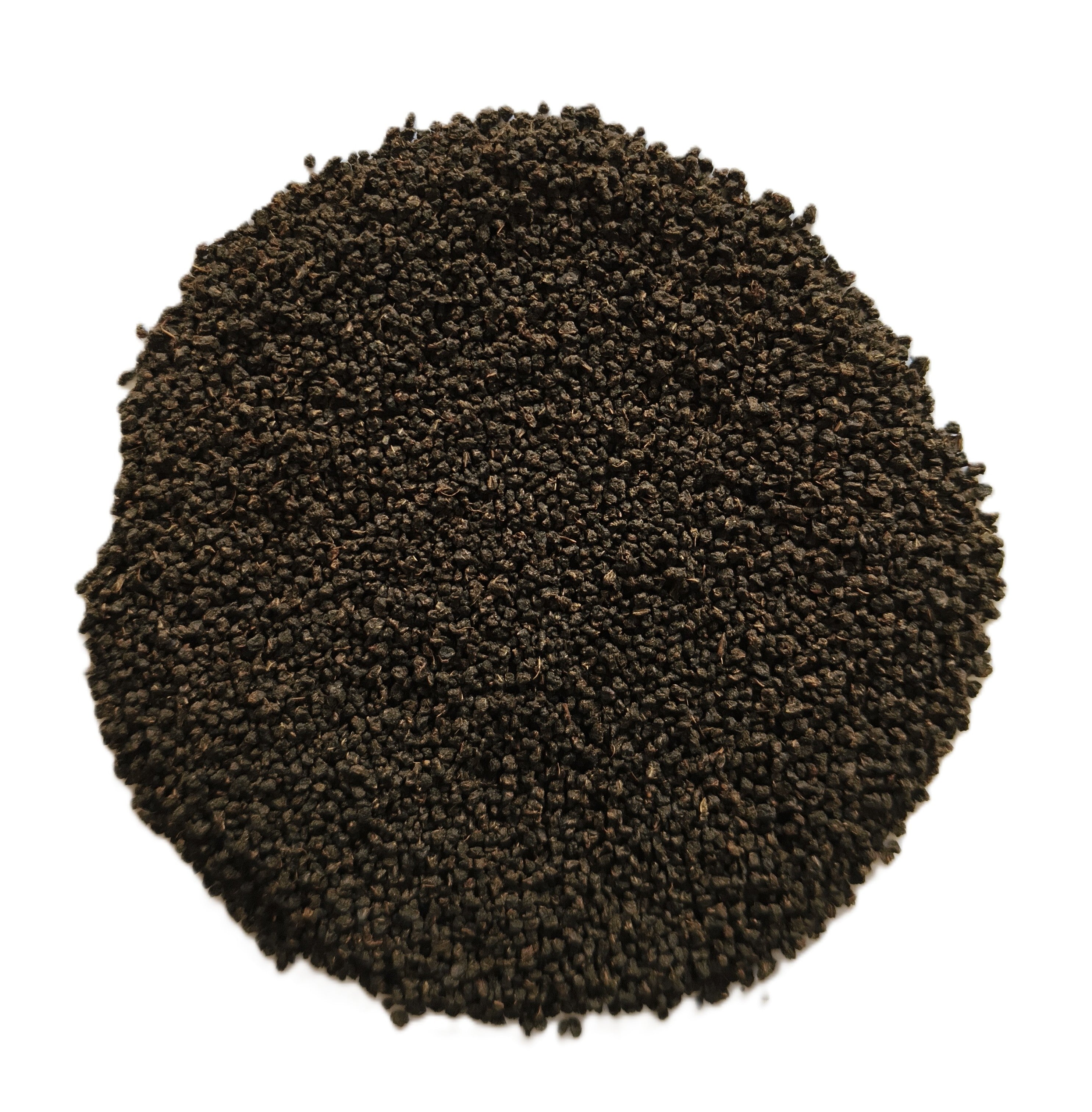 A circular pile of dark brown to black granular material, likely coffee grounds or seed pods, photographed from directly above on a solid white background.