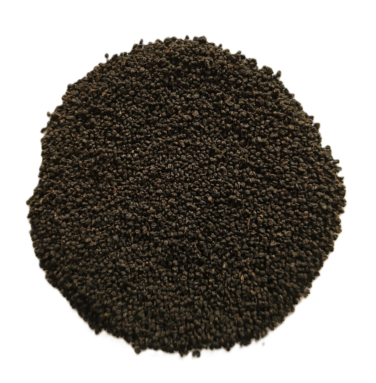 A circular pile of dark brown to black granular material, likely coffee grounds or seed pods, photographed from directly above on a solid white background.