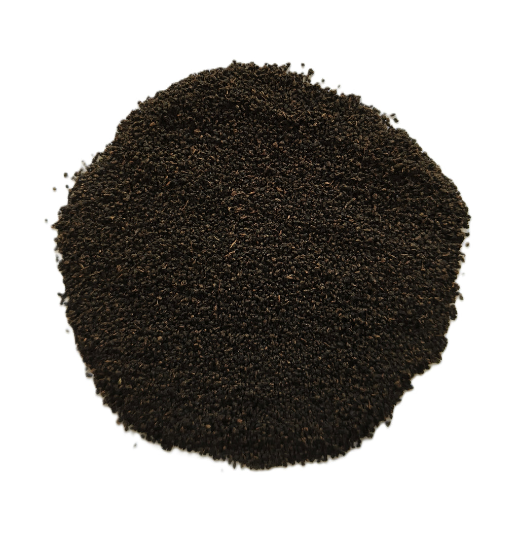 A pile of dark brown to black coarse sand or gravel, photographed from directly above on a solid white background.