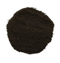 A pile of dark brown to black coarse sand or gravel, photographed from directly above on a solid white background.