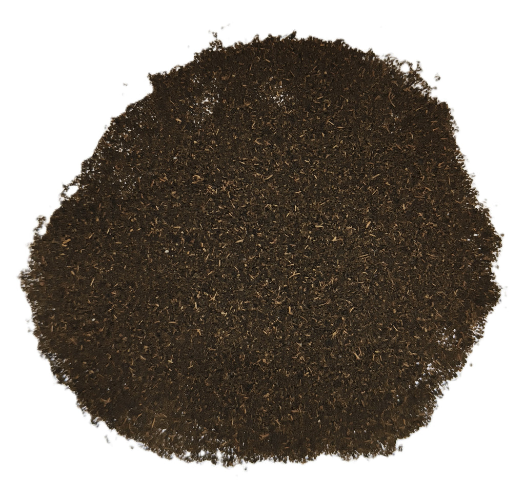 A pile of dark brown loose-leaf tea or herb blend on a plain white background.