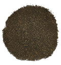 A circular pile of dark brown shredded material, likely coffee grounds or tea leaves, photographed from directly above on a solid white background.