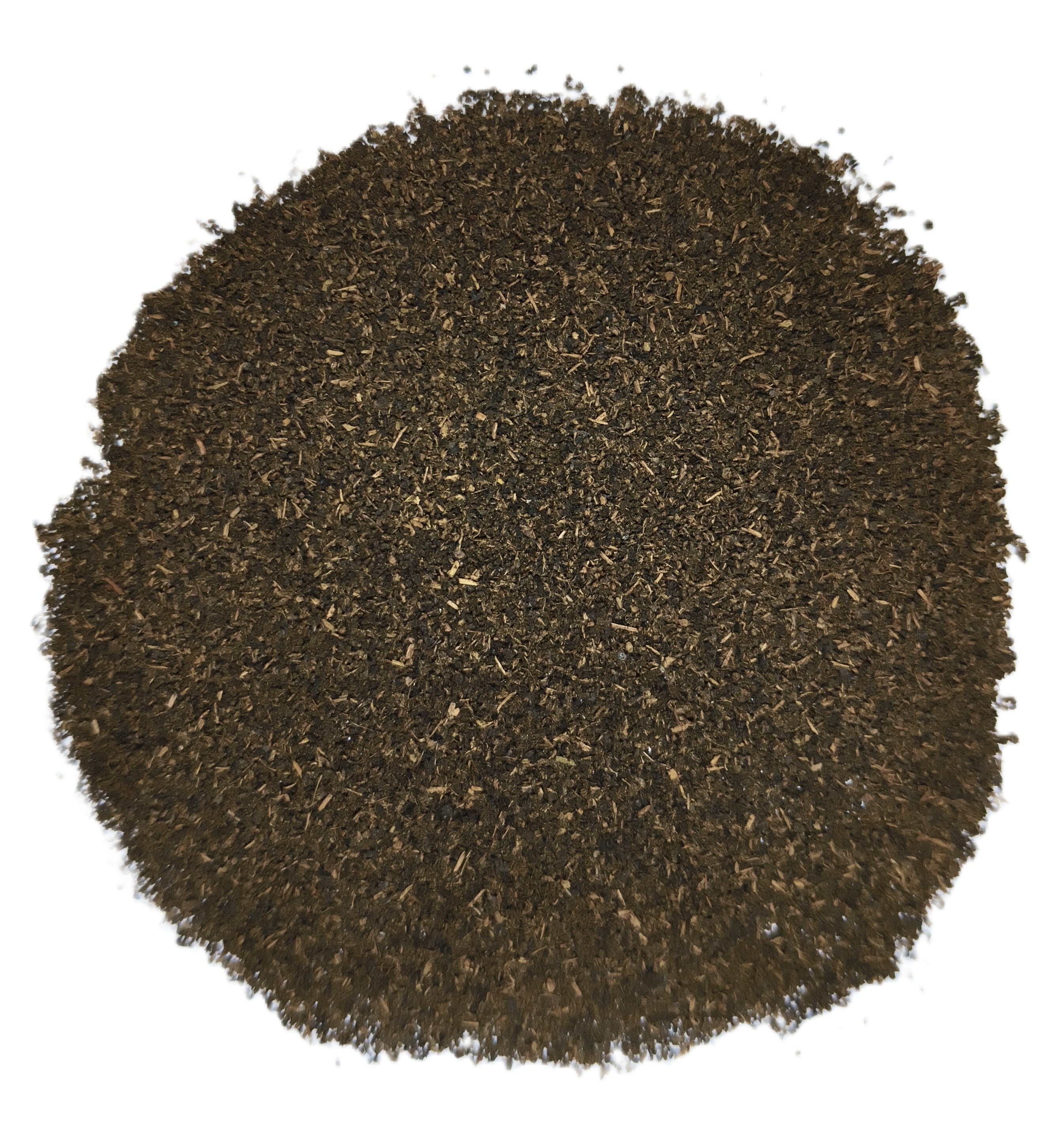 A circular pile of dark brown shredded material, likely coffee grounds or tea leaves, photographed from directly above on a solid white background.