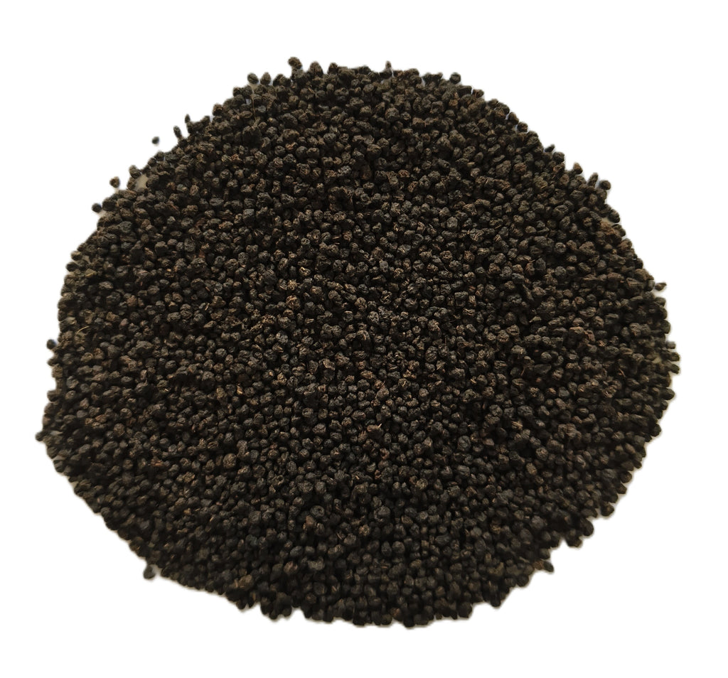 A pile of small dark brown to black seeds or grains photographed from above on a plain white background.