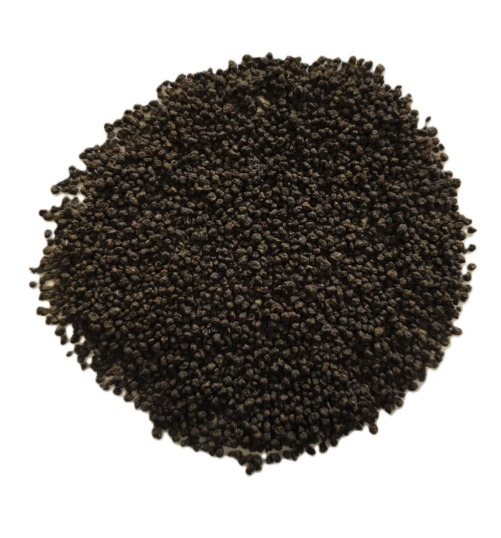 A pile of small dark brown to black seeds, likely sesame seeds, photographed from directly above on a plain white background.