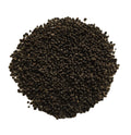 A pile of dark brown to black textured granules, likely coffee beans or ground coffee, photographed from directly above on a solid white background.