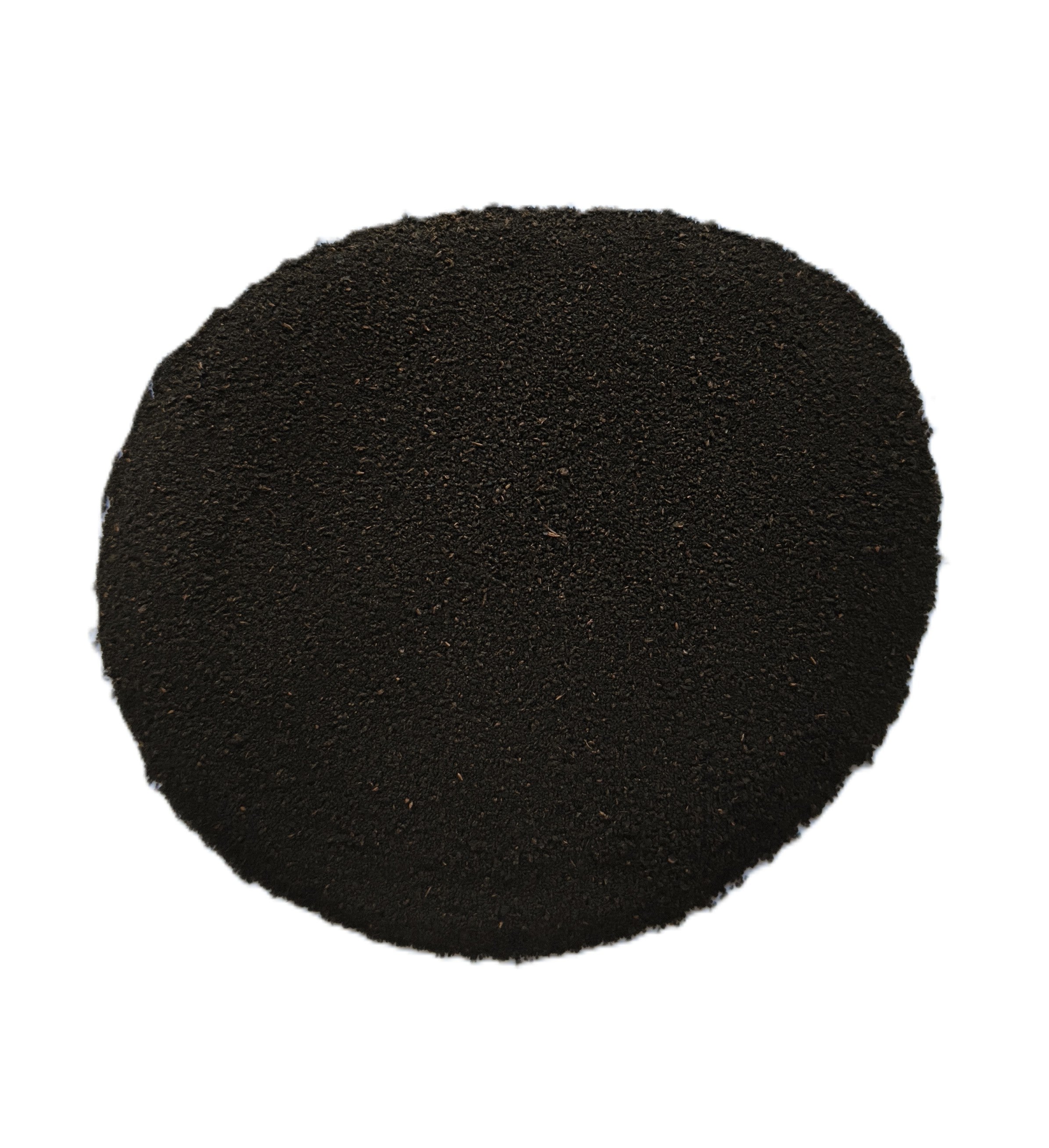 A circular pile of dark black granular powder or substrate material on a solid white background.