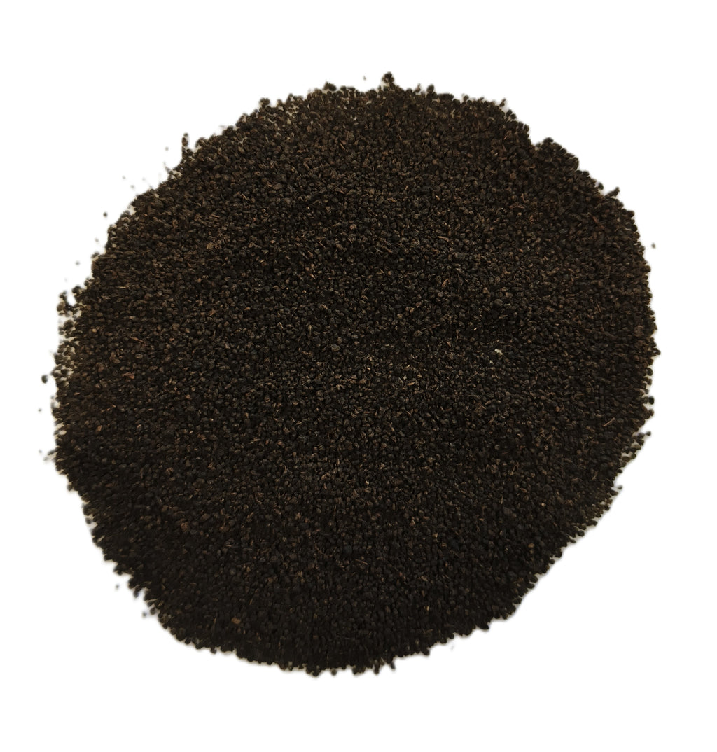 A pile of dark brown to black granular powder or substrate material, photographed from directly above on a plain white background.