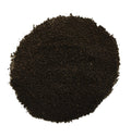 A pile of dark brown to black granular powder or substrate material, photographed from directly above on a plain white background.