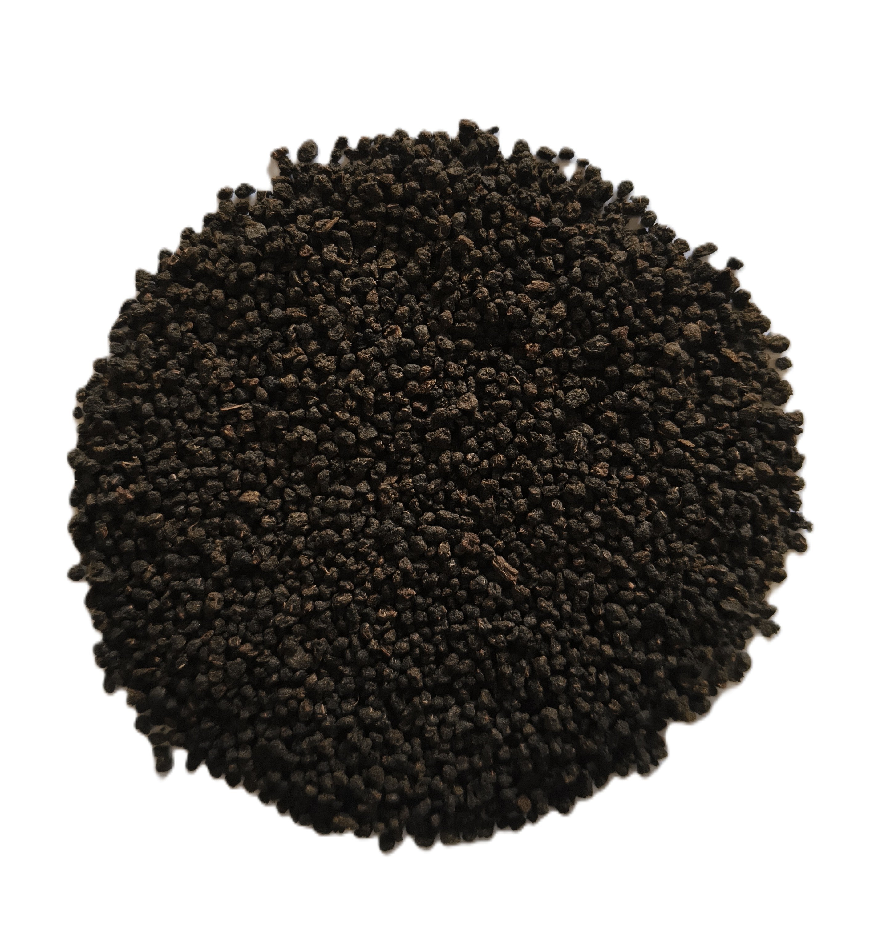 A pile of dark brown to black textured granules, likely coffee beans or a similar ground ingredient, photographed from directly above on a solid white background.