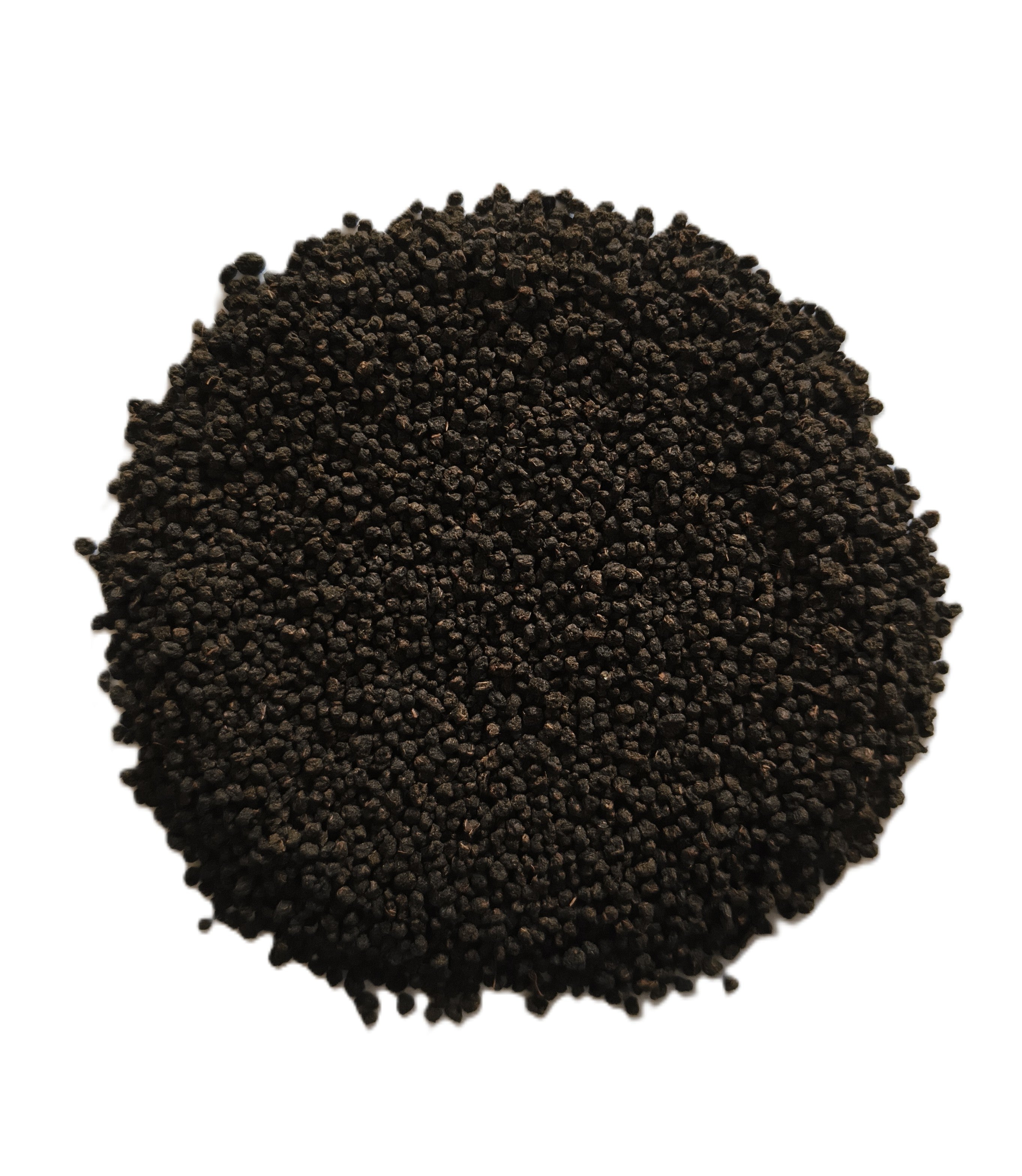 A pile of small dark brown to black granular seeds or pellets, photographed from above on a plain white background.