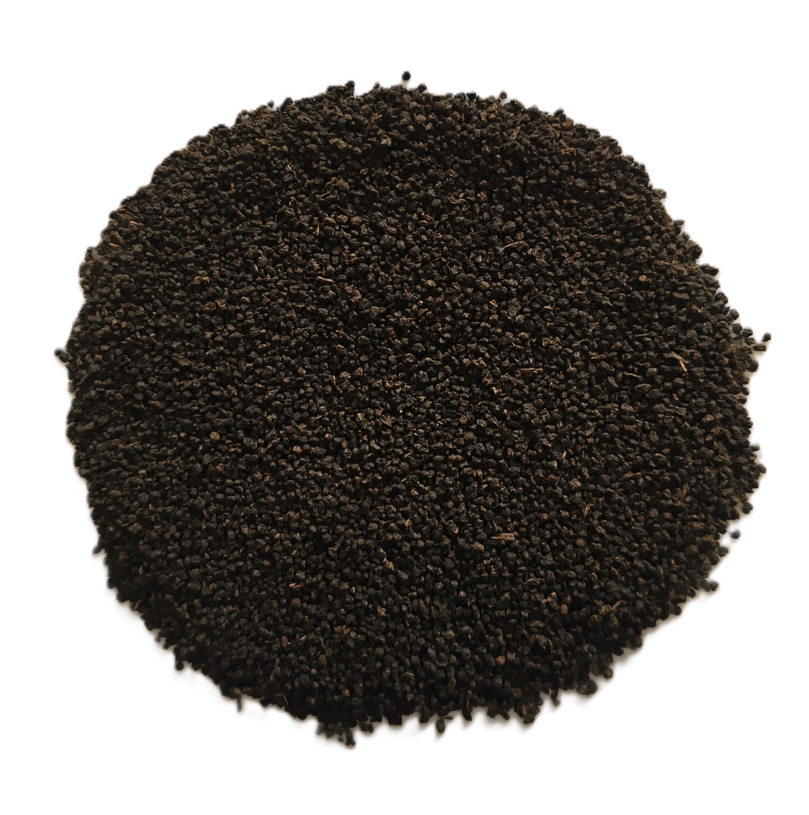 A pile of dark brown to black textured seeds or granules, photographed from directly above on a plain white background.