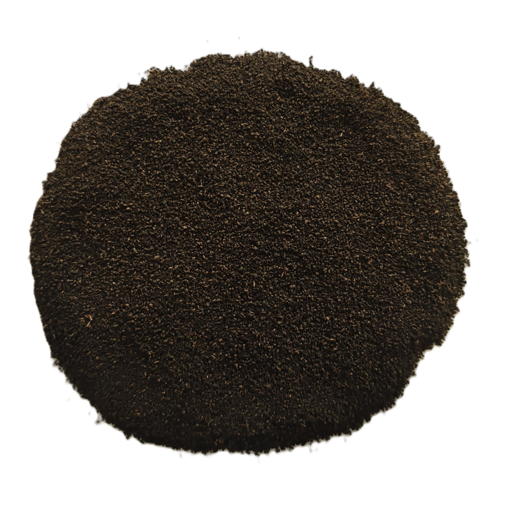 A circular pile of dark brown to black granular powder or substrate material, photographed from directly above on a plain white background.