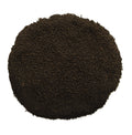 A circular pile of dark brown to black granular powder or substrate material, photographed from directly above on a plain white background.