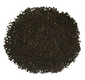 A pile of dark brown to black textured granules, likely coffee beans or tea leaves, photographed from directly above on a solid white background.
