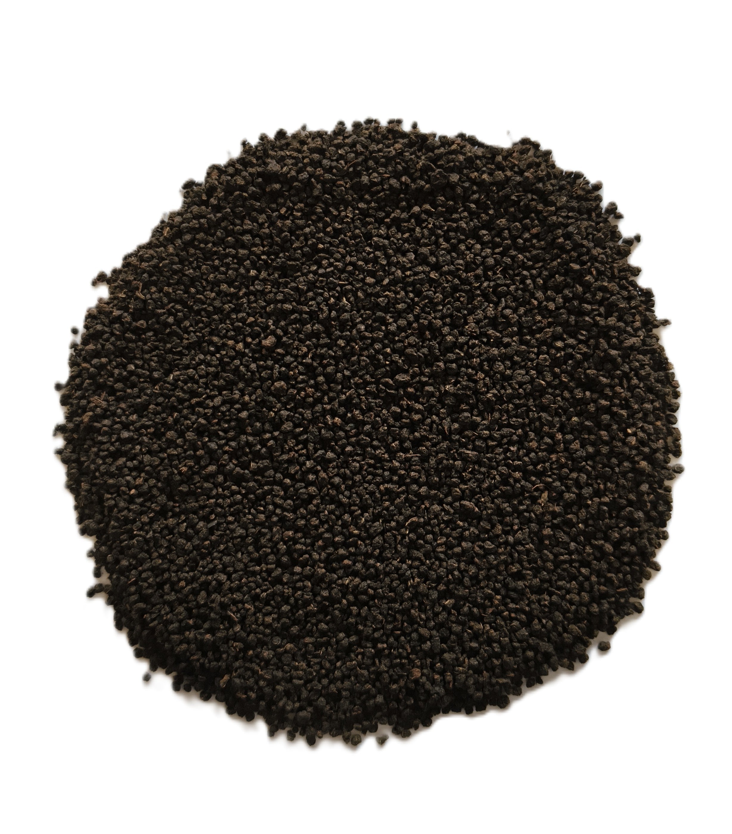 A circular pile of small dark brown to black seeds or granules on a plain white background.